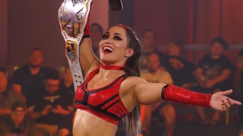 Roxanne Perez  holds up her title