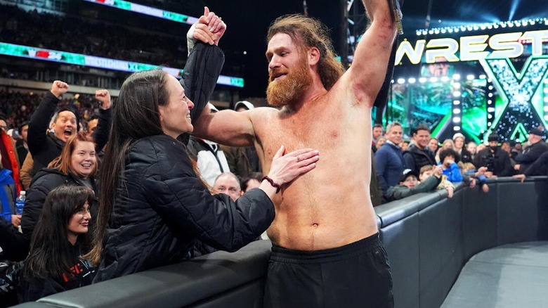 Sami Zayn celebrates his WWE Intercontinental Championship victory with his wife.