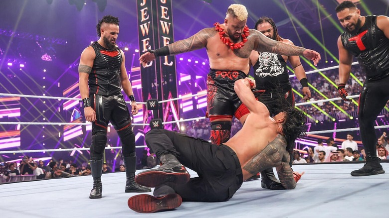 Solo Sikoa and The Bloodline stand over a defeated Roman Reigns