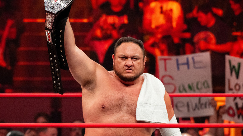 Samoa Joe holding up championship belt