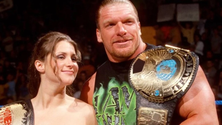 Women's Champion Stephanie McMahon holds her title while standing beside real-life husband Triple H, the WWF Champion