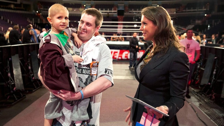 Connor "The Crusher" Michalek, his father Steve, and Stephanie McMahon have a conversation at a WWE event.
