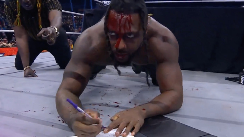 Swerve Strickland signs his AEW World Championship contract in blood.