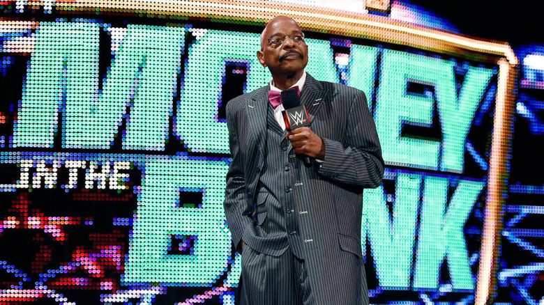 Teddy Long stands with microphone