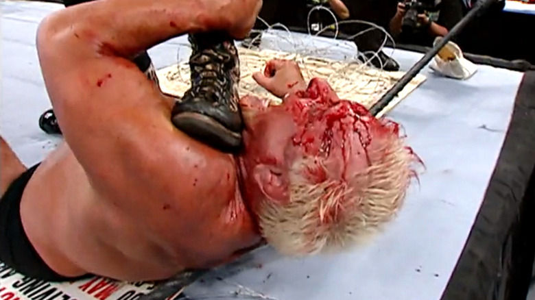 Mick Foley's boot comes down on Ric Flair's neck