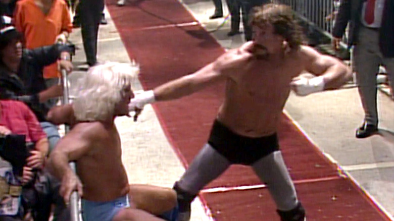 Terry Funk attacks Ric Flair outside the ring