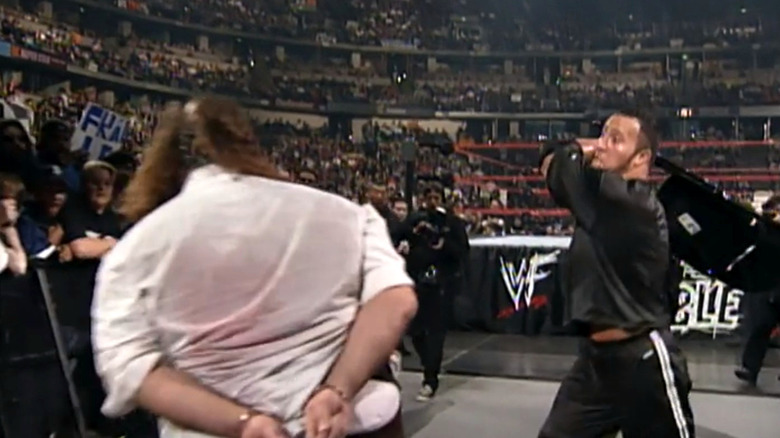 The Rock hits Mick Foley with a chair