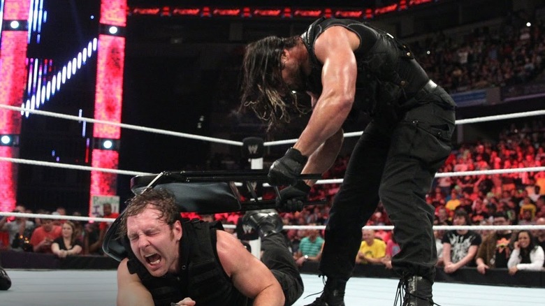 Rollins hits Ambrose with Chair