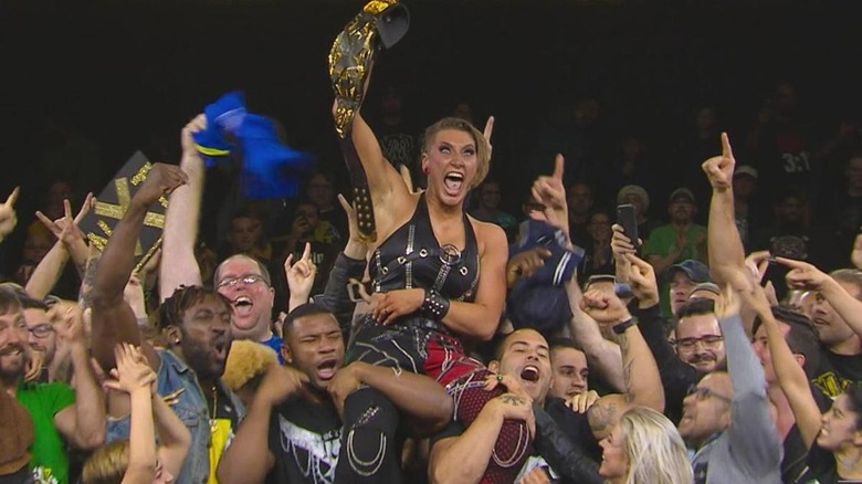 Rhea Ripley being held up after her championship win