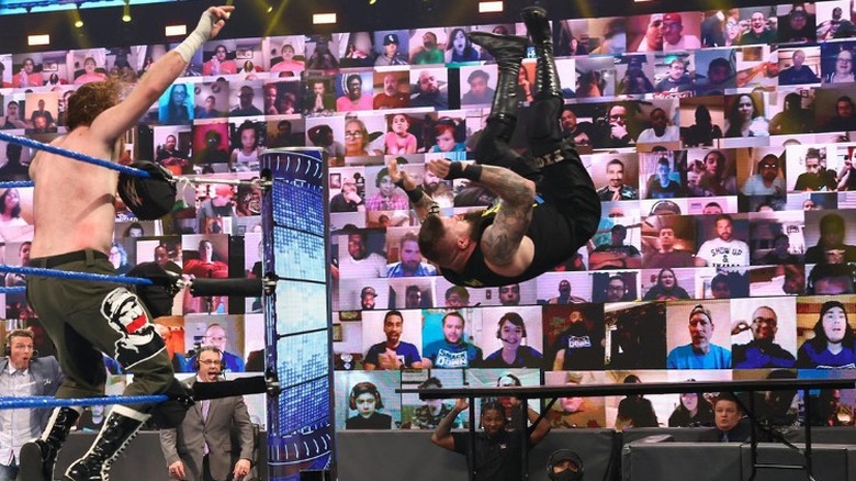 Kevin Owens being thrown off the top rope onto a tower of tables