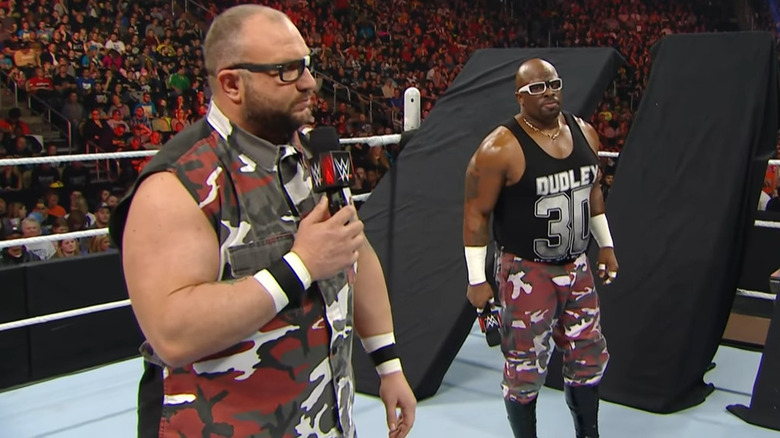 The Dudley Boyz in front of tables
