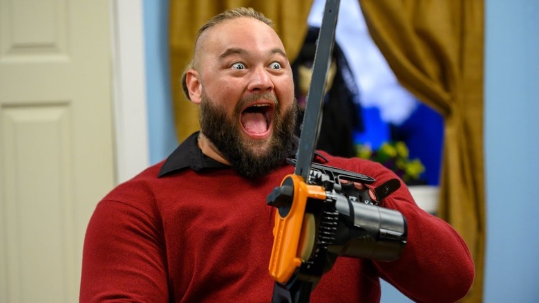 Bray holding a chainsaw