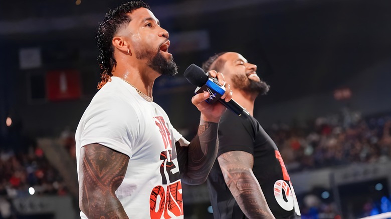 Jey Uso with a microphone, Jimmy by his side