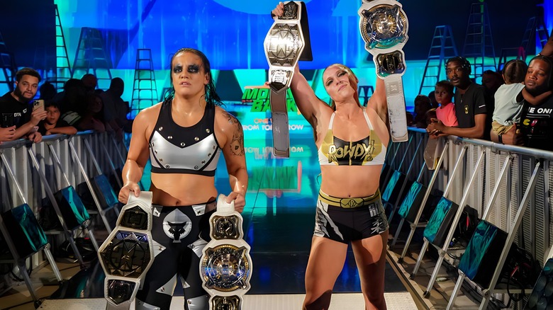 Shayna Baszler and Ronda Rousey holding their titles