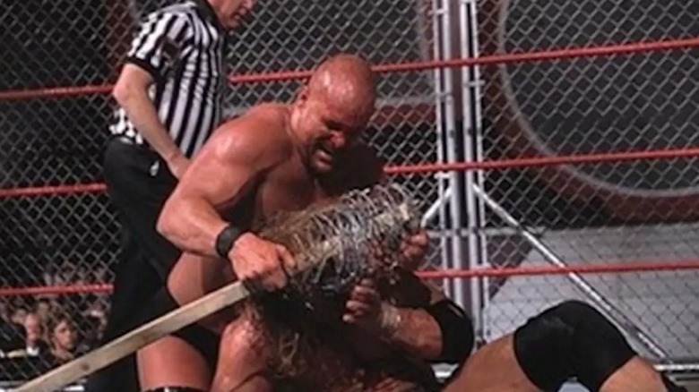 Steve Austin attacks Triple H with barbed-wire bat