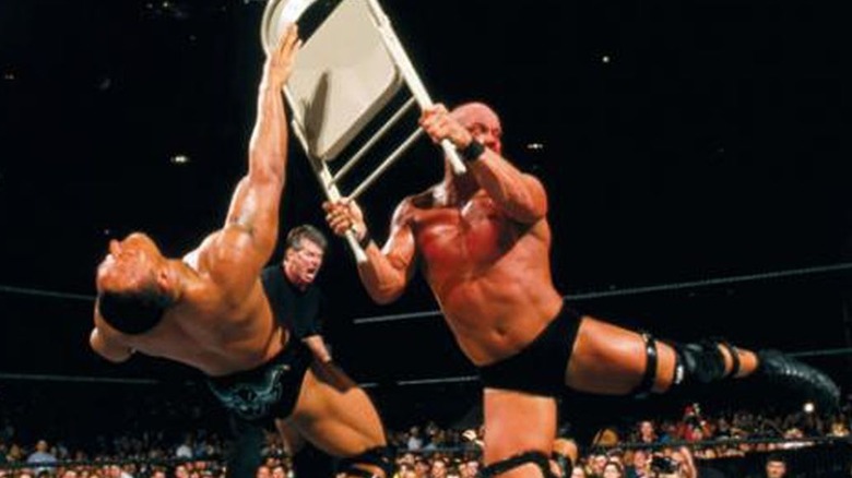Steve Austin hits The Rock with a chair