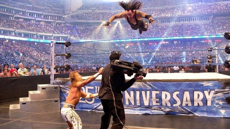 The Undertaker dives onto Shawn Michaels and cameraman