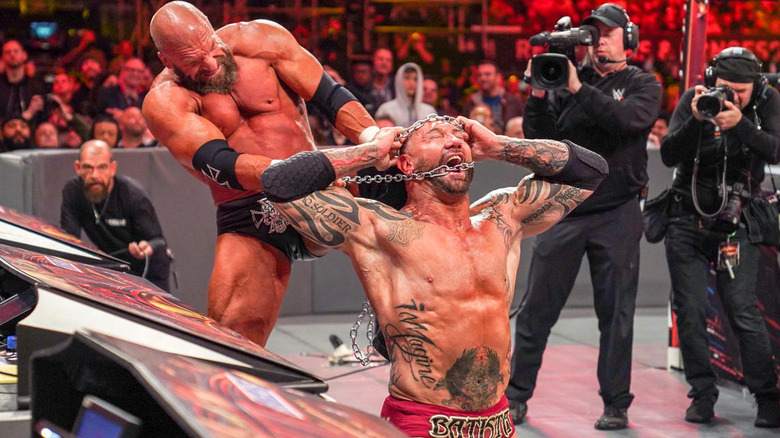 Triple H strangling Batista with a chain