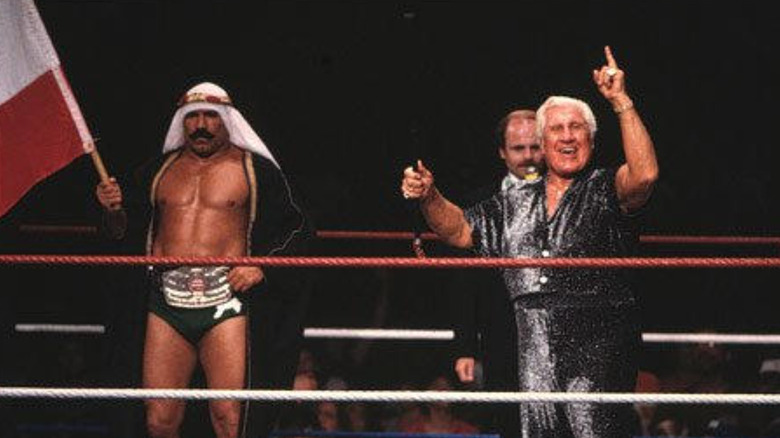 Freddie Blassie gloats next to Iron Sheik