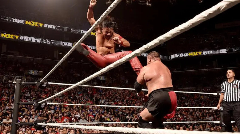 Nakamura hits Joe with a jumping kick
