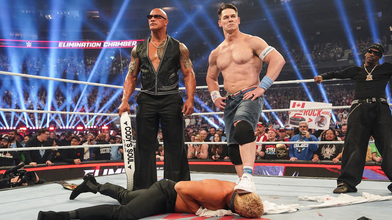 Dwayne "The Rock" Johnson, John Cena, and Travis Scott stand over Cody Rhodes during WWE Elimination Chamber at Rogers Centre on March 1, 2025 in Toronto, Canada.