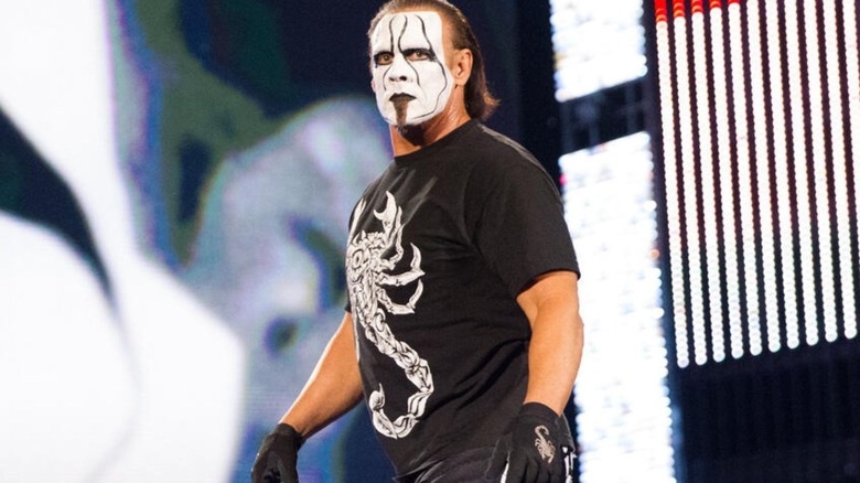 Sting heads down to the ring for a match in WWE, wearing his iconic "Crow" black and white face paint and wearing a scorpion t-shirt.