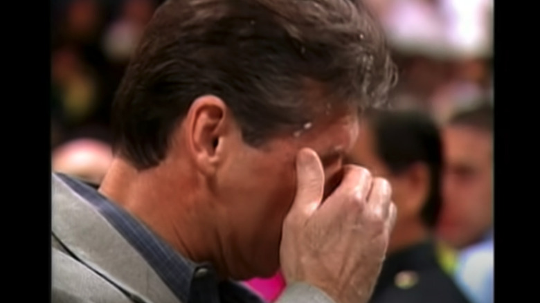 Vince McMahon wipes Bret Hart's spit from his face