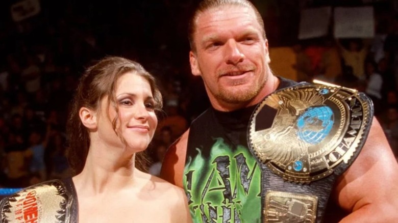 Stephanie McMahon is seen holding the Women's Championship beside her real life husband, the then-WWF Champion Triple H.