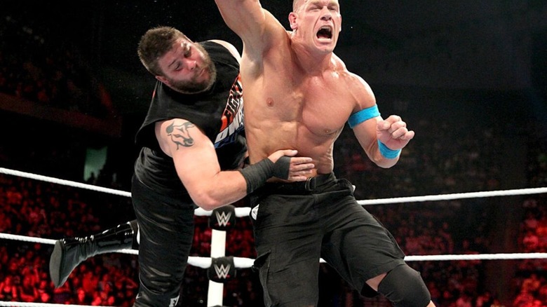 Kevin Owens hits John Cena from behind in the middle of the ring during their match at Elimination Chamber in 2015.