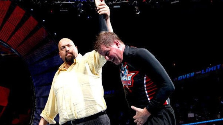 Big Show holds up the hand of John Laurinaitis in victory, after he defeated John Cena at WWE's Over the Limit Event.