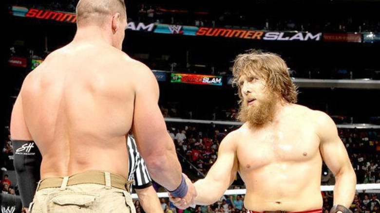 Daniel Bryan shakes John Cena's hand in the middle of the ring after winning the WWE Championship from him at SummerSlam in 2013.