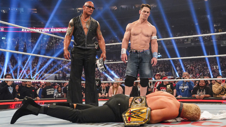 Dwayne "The Rock" Johnson and John Cena stand over Cody Rhodes during WWE Elimination Chamber at Rogers Centre on March 1, 2025 in Toronto, Canada.