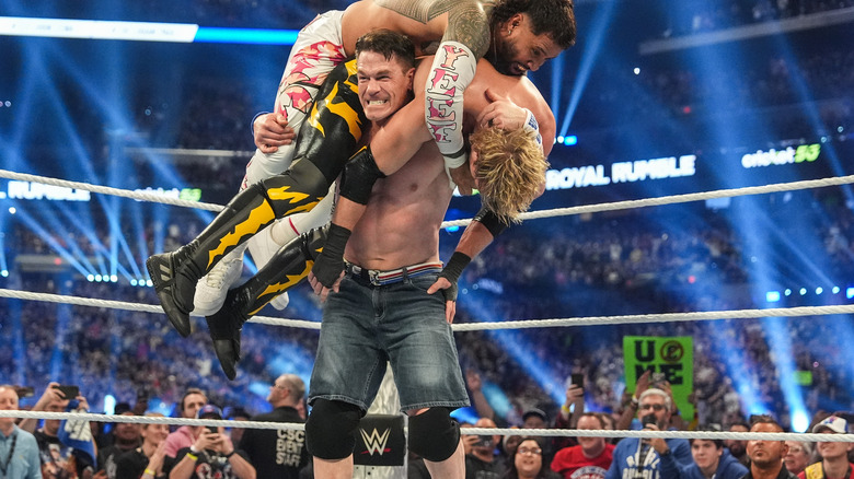 John Cena with Jey Uso and Logan Paul on his shoulders at WWE Royal Rumble