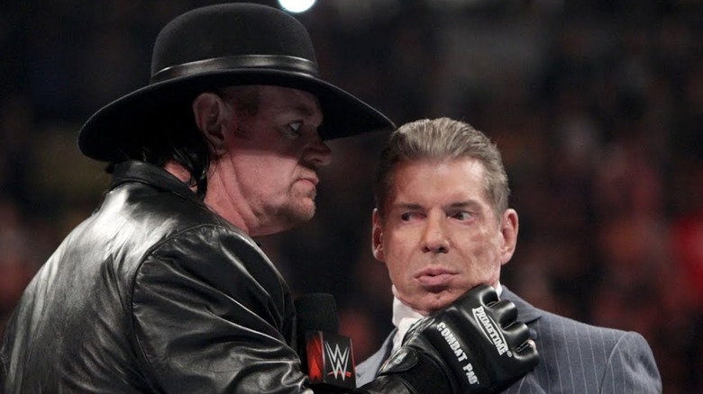 Undertaker with his hand around Vince McMahon's throat