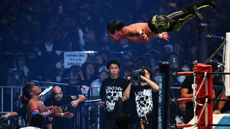Kenny Omega diving over the ropes