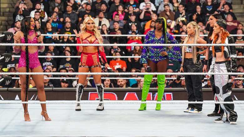 Bianca Belair, Tiffany Stratton, Naomi, Liv Morgan, Raquel Rodriguez, and Becky Lynch standing in the ring