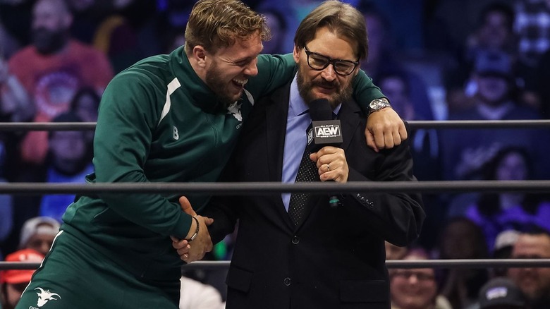 Will Ospreay hugs Tony Schiavone and shakes his hand at the same time