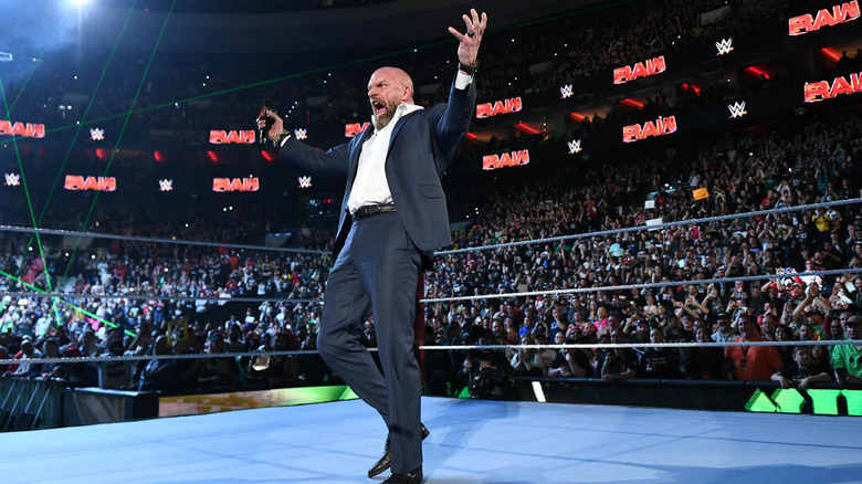 Triple H roars with arms spread