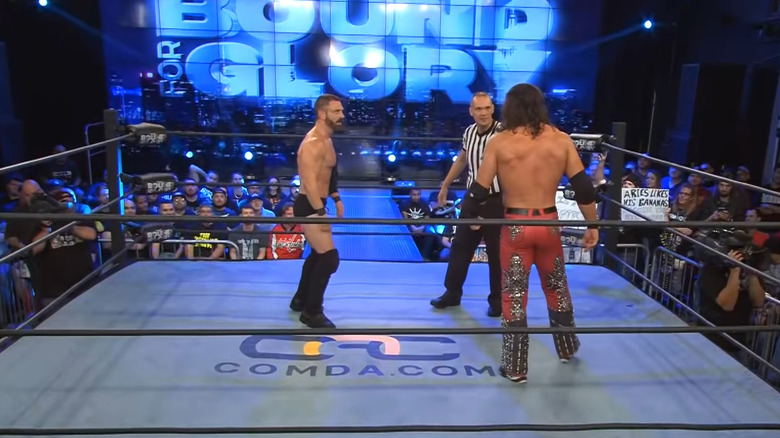 Austin Aries in the ring with Johnny Impact
