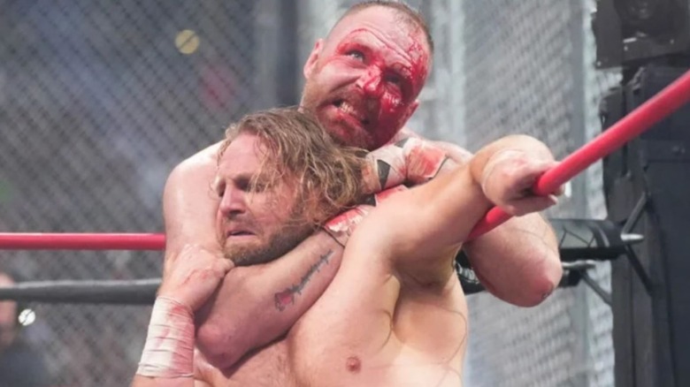 A bloodied Jon Moxley puts "Hangman" Adam Page in a chokehold