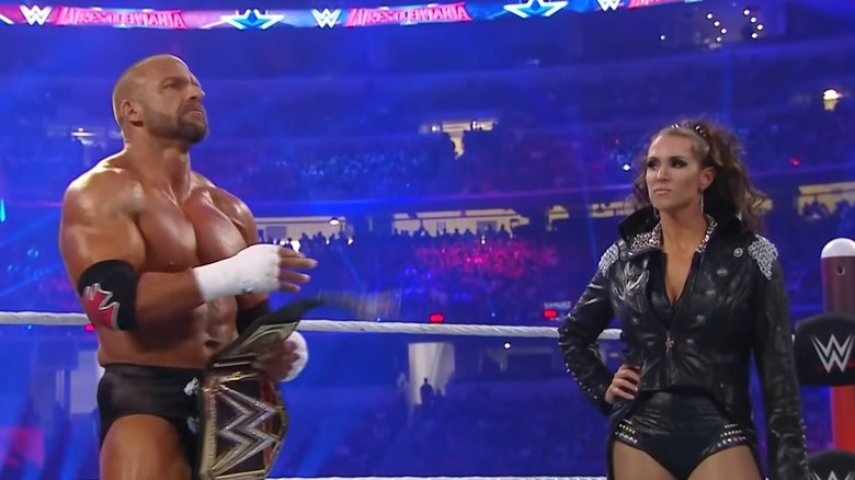 Triple H and Stephanie McMahon standing in the ring
