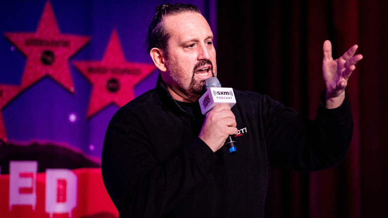 Tommy Dreamer holding a mic and gesturing with his hand