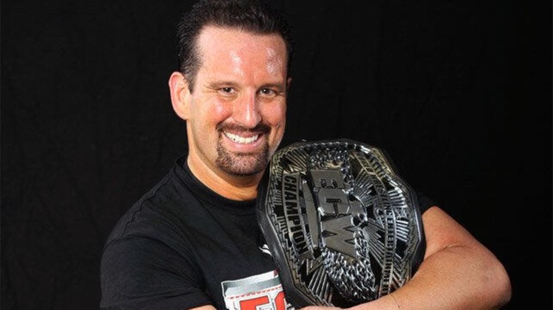 Tommy Dreamer posing with the WWE ECW World Championship during a photo shoot.