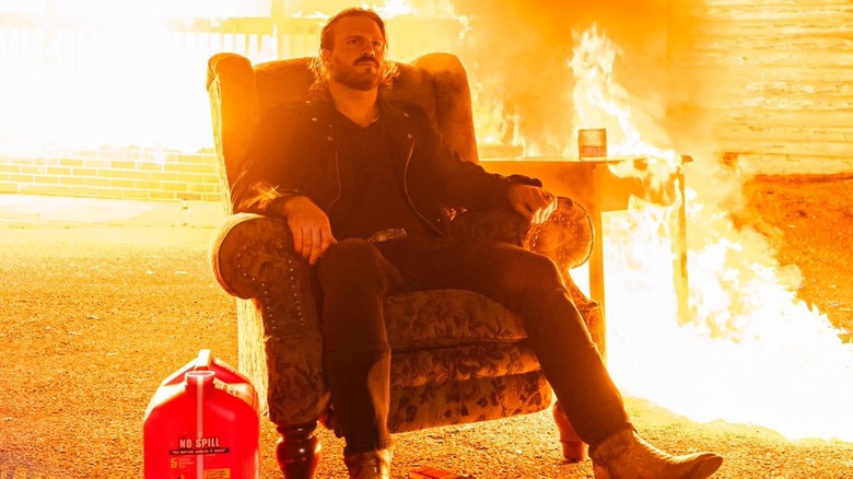 "Hangman" Adam Page sits in front of a burning house