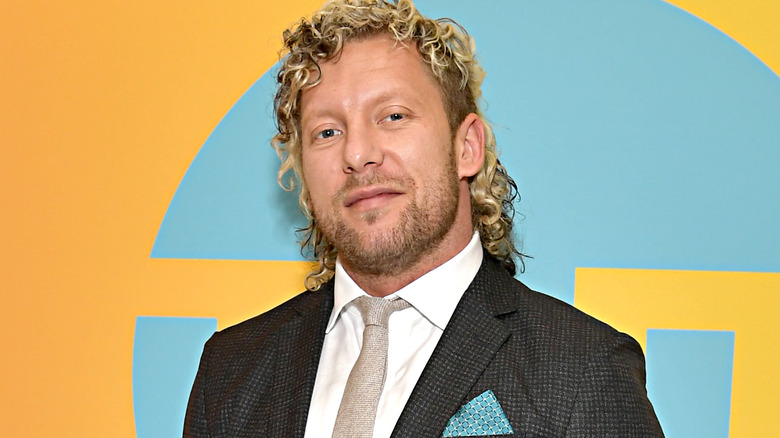 Kenny Omega wearing a gray suit