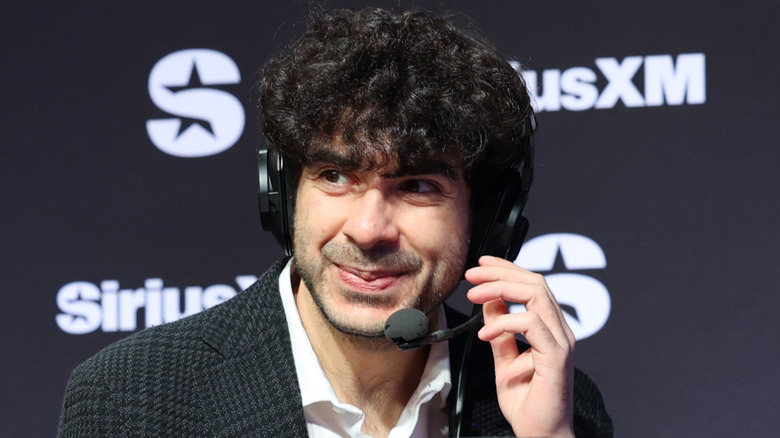 Tony Khan smiling and wearing a headset