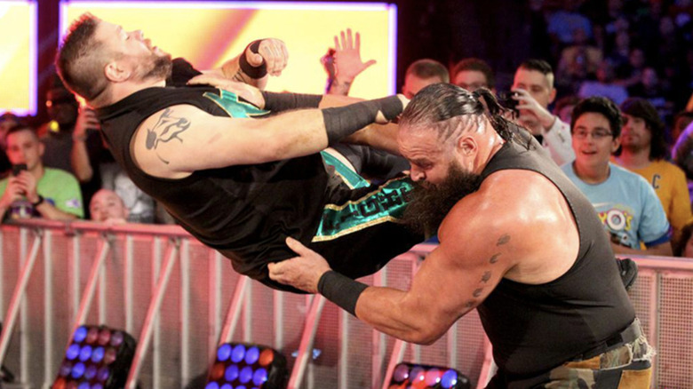 Braun Strowman chokeslamming Kevin Owens