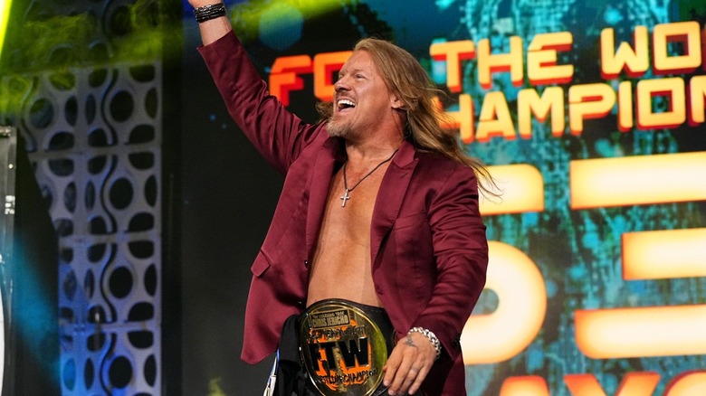 Chris Jericho, sporting the For the World Championship, waves excitedly to the crowd.