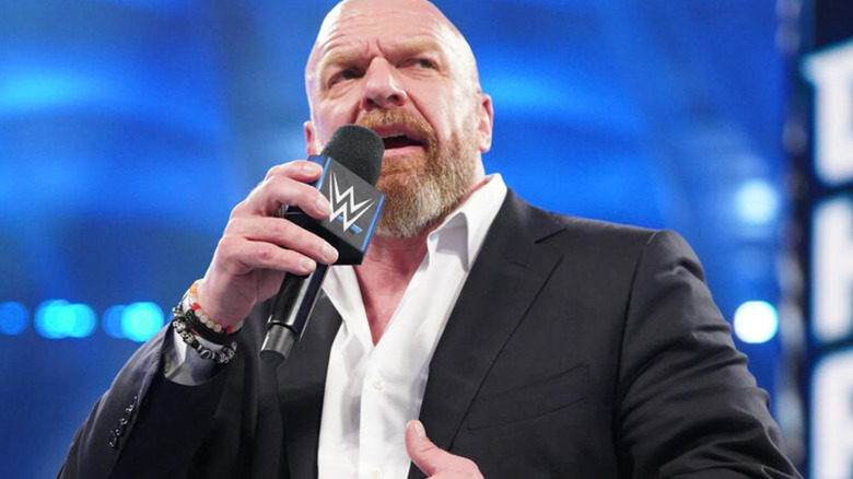 Triple H speaks into a WWE microphone.