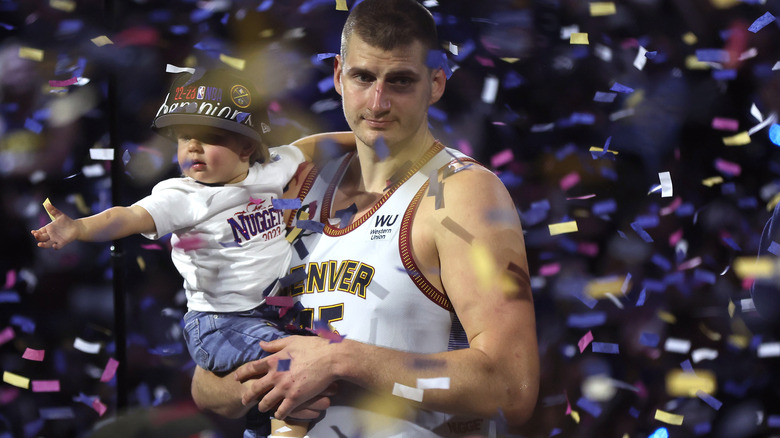 Nikola Jokic celebrates Denver's win with his daughter